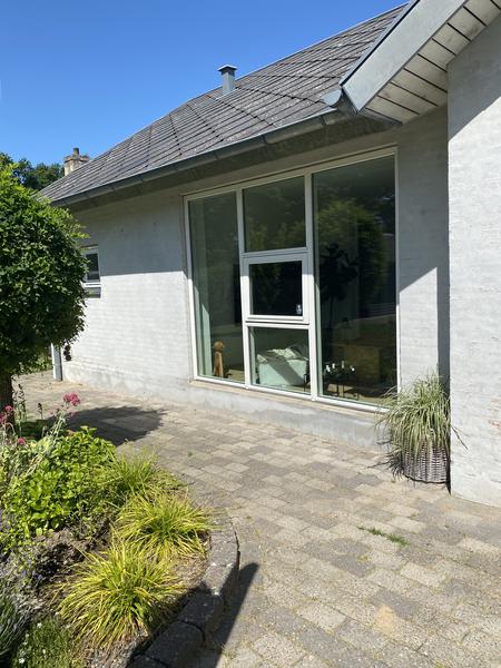 Maling af hus med sandfarvet facade og sort sokkel